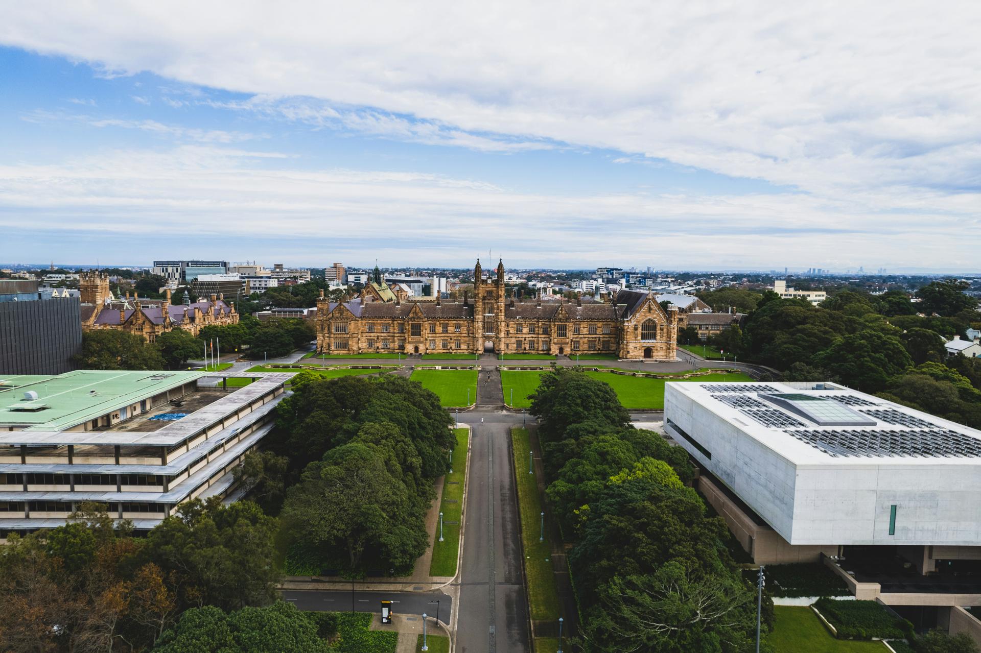 Study in Australia - University of Melbourne historic sandstone buildings with lush green campus grounds in Victoria for Indian students