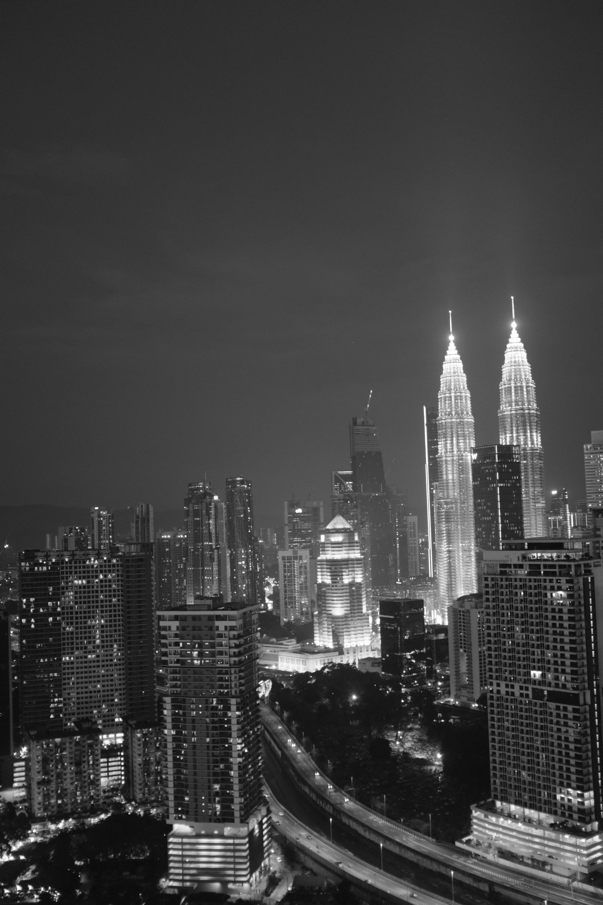 Kuala Lumpur skyline with iconic Petronas Twin Towers at dusk surrounded by modern skyscrapers